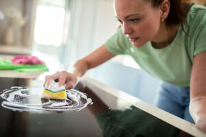 Close up of a young woman using cleaning products to clean the kitchen